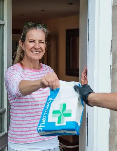 A woman taking prescription delivery from her door